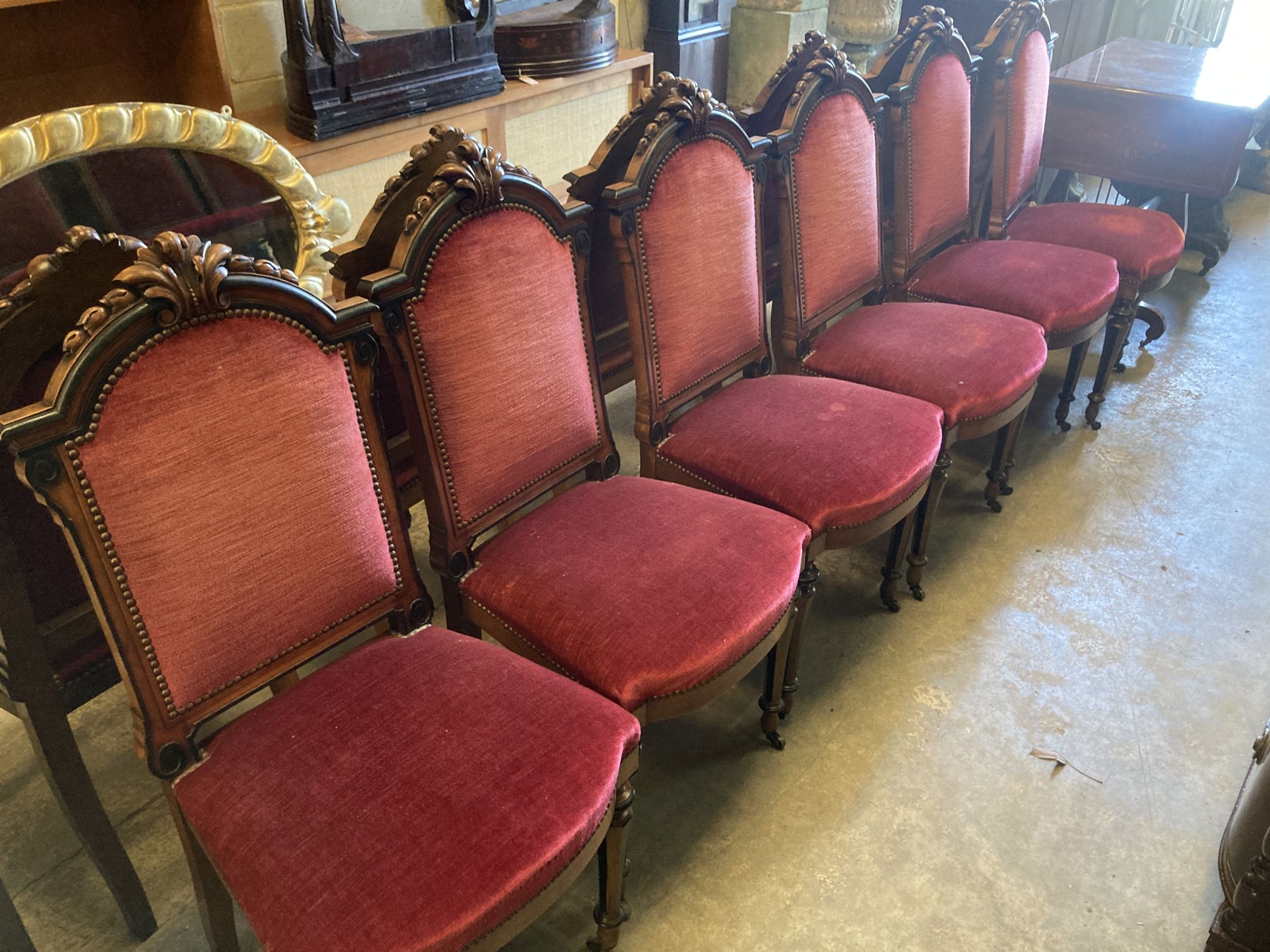 A set of twelve 19th century Continental walnut part ebonised carved walnut dining chairs